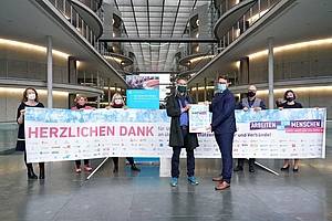 Eine Gruppe von Menshen mit einem langen Banner im Abgeordnetenhaus in Berlin.
