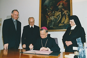 Der Bischof unterschreibt das Dekret zur Stiftungsgründung